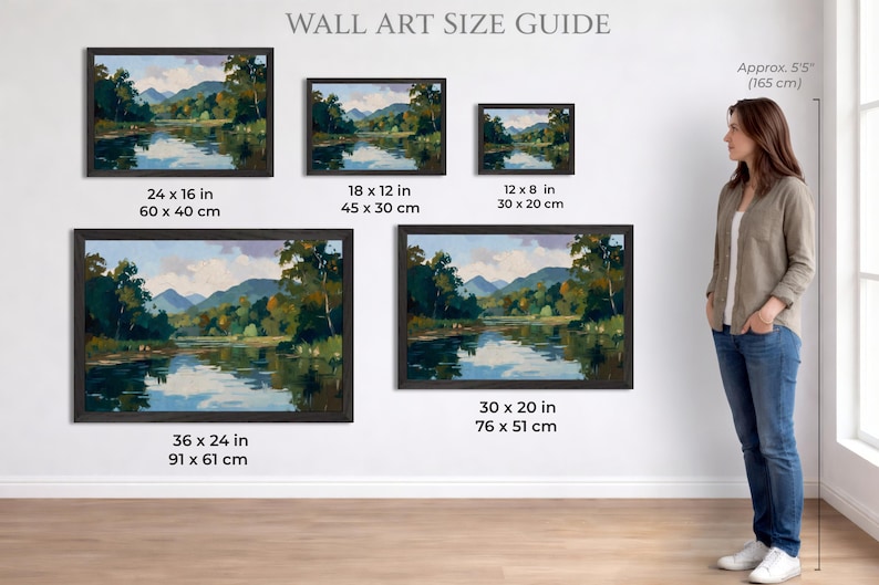 Puede incluir: Gu&iacute;a de tama&ntilde;os de arte mural con pinturas de paisajes enmarcadas. Las pinturas representan una serena escena de r&iacute;o con monta&ntilde;as y &aacute;rboles. Los tama&ntilde;os var&iacute;an de 30 x 20 cm a 91 x 61 cm. Una mujer est&aacute; de pie junto a la exhibici&oacute;n, de aproximadamente 165 cm.