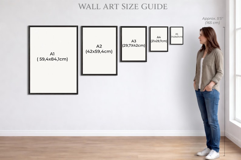 Puede incluir: Gu&iacute;a de tama&ntilde;os de arte mural con ejemplos enmarcados etiquetados A1 (59,4x84,1cm), A2 (42x59,4cm), A3 (29,7x42cm), A4 (21x29,7cm) y A5 (14,8x21cm). Una mujer est&aacute; de pie junto a la pared, aproximadamente 165 cm de altura.