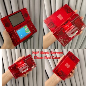 Puede incluir: Una consola de juegos port&aacute;til Nintendo DS roja transparente. La consola est&aacute; abierta, mostrando un juego en la pantalla inferior y una pantalla negra en la superior. El texto "Half Black Screen Clean Red Case" es visible.