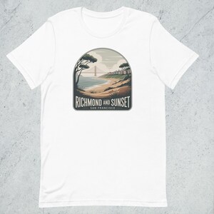 Puede incluir: Camiseta blanca con un diseño gráfico de un paisaje costero, con el Golden Gate Bridge, árboles y el texto "Richmond and Sunset San Francisco". El diseño es de estilo vintage.