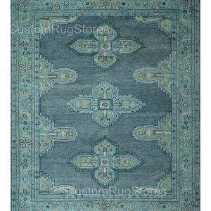Peut inclure: Tapis rectangulaire bleu et turquoise avec un motif central de formes géométriques et florales. Le tapis présente une bordure détaillée. Le texte "CustomRugStores" est visible. Le design est complexe et orné.