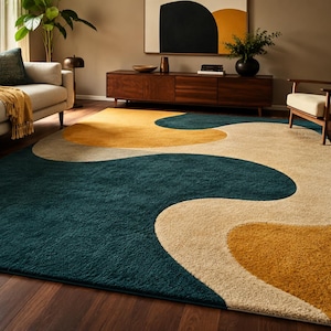Könnte beinhalten: Ein großer Teppich mit modernem Design. Der Teppich hat ein abstraktes Muster in den Farben Teal, Beige und Senfgelb. Der Teppich liegt auf einem dunklen Holzboden in einem Wohnzimmer.