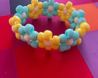 Brazalete Kandi de flores en tonos aguamarina y amarillo (talla S) con cuentas en tonos pastel