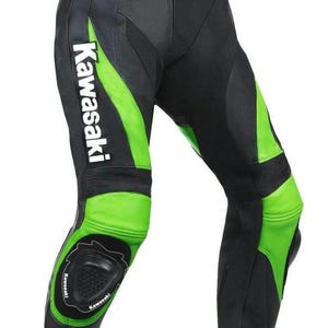 以下が含まれることがあります： 黒と緑のオートバイ用パンツ。白いKawasakiのロゴ入り。膝と側面に緑色のアクセントがあり、保護パッドが付いています。オートバイに乗るために設計されており、耐久性のある素材で作られています。