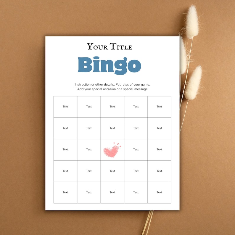 May include: A white Bingo game card with the title "YOUR TITLE" and the word "Bingo" in blue. The card includes instructions and a grid of boxes labeled "Text", with a pink heart graphic. Dried flowers are in the background.