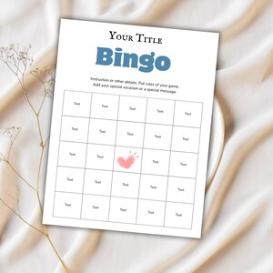 May include: A white Bingo game sheet with the title "Bingo" in blue, and the words "Your Title" above it. The sheet has a grid of boxes with the word "Text" in each. A pink heart graphic is in the center. The text "Instruction or other details. Put rules of your game. Add your special occasion or a special message" is also present.