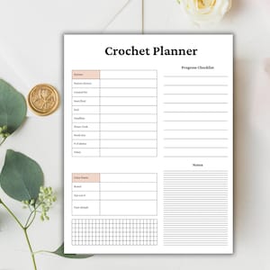 May include: A white Crochet Planner with sections for pattern details, progress checklist, and notes. The planner includes spaces for yarn information and a grid for tracking. The title "Crochet Planner" is in bold black font.