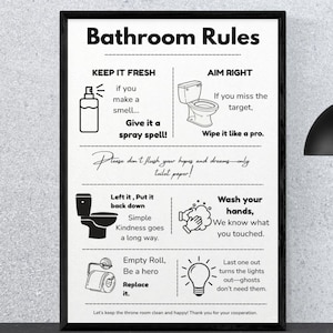 May include: Black framed bathroom rules sign with white background. The sign includes text and illustrations with instructions such as "Keep it fresh" and "Aim right". The sign is a decorative item for a bathroom.