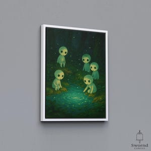 May include: A framed canvas art print shows five small, pale green figures around a shimmering pool in a dark forest. The figures have large, oval eyes, surrounded by green foliage and a starry night sky. The artwork is framed in white.