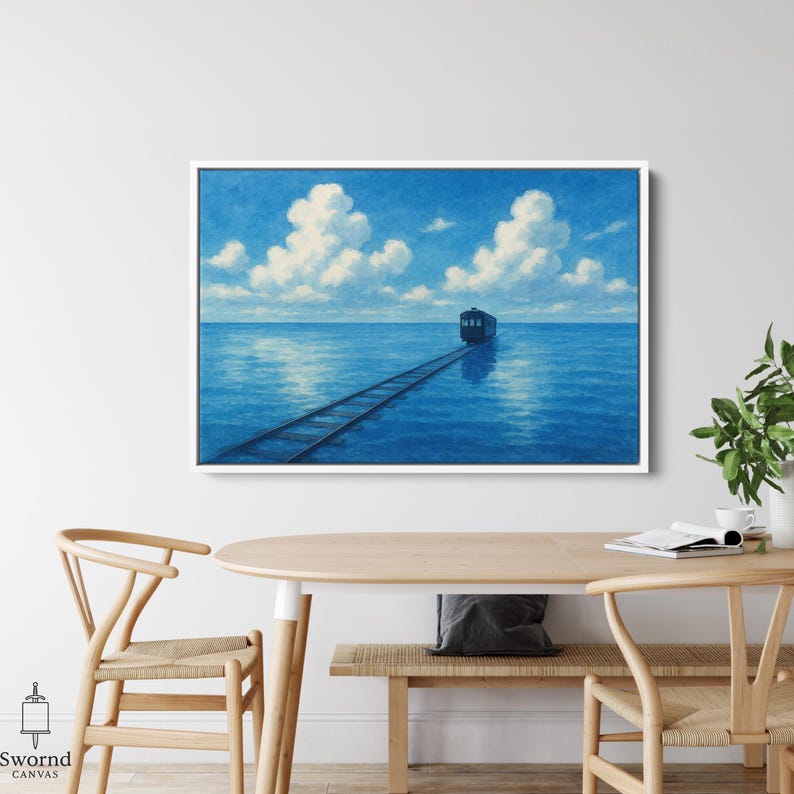 May include: A framed art print depicts a train traveling on tracks across a vast blue ocean under a sky filled with fluffy white clouds. The artwork has a serene, dreamlike quality, with the train as the focal point.