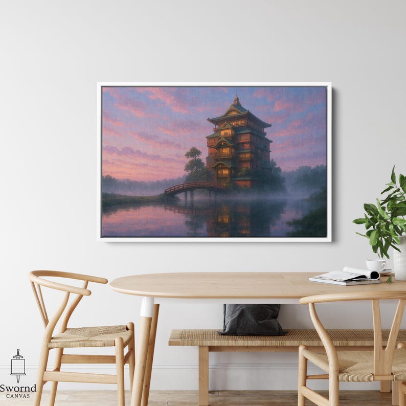 May include: A framed canvas print depicts a Japanese-style building on an island, connected by a bridge. The artwork features a sunset with pink and purple hues, reflecting in the water. The building has multiple stories and warm lighting.