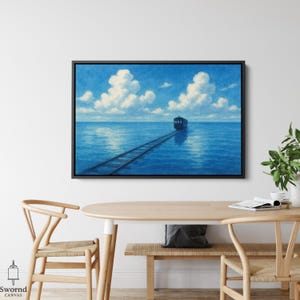 May include: A framed canvas print depicts a train traveling on tracks across a vast, blue ocean under a bright, cloudy sky. The artwork is set in a black frame and hangs on a white wall. The overall theme is a serene, dreamlike landscape.