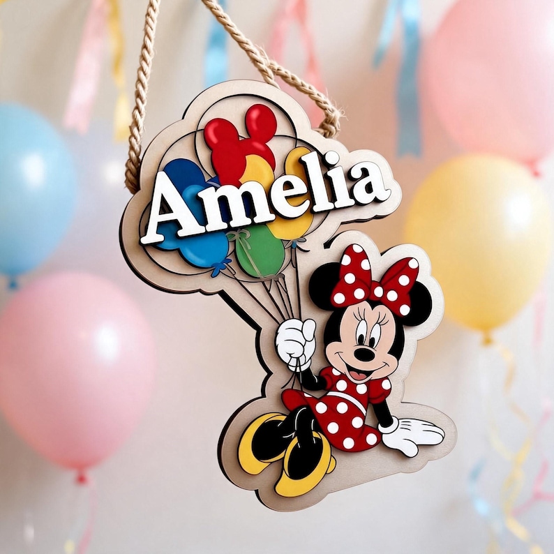 May include: Wooden sign with Minnie Mouse holding balloons, and the name "Amelia". The sign is cloud-shaped and has a rope for hanging. The design includes red, yellow, blue, and green balloons. The background features more balloons.