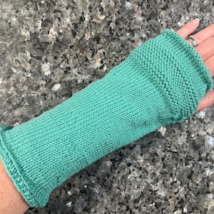 Może przedstawiać: Ciepły, zielony, dzianinowy ochraniacz na rękę z żebrowaną fakturą.