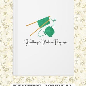Op de afbeelding: Wit notitieboek met een groene brei-afbeelding en de tekst "Knitting Work in Progress". Het notitieboek heeft ook de tekst "Knitting Journal For All Your Projects" onderaan. De achtergrond is een bloemenpatroon.