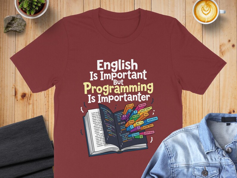T-shirt with text "English Is Important But Programming Is Importanter" and code snippets.