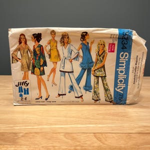 May include: A Simplicity 8234 sewing pattern envelope featuring illustrations of six different outfits including dresses, tunics, and pants with various patterns and solid colors. The text includes Simplicity 8234, Size 10, Bust 32 1/2, and Jiffy.