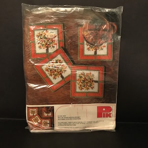 May include: A plastic bag containing a needlepoint kit for four autumn leaf coasters. The kit includes 7 mesh plastic canvas, 2 ply persian type acrylic yarn, finished size 4 in. x 4 in. and illustrated instructions. The kit is from the Pik Corporation, Elizabeth, N.J.