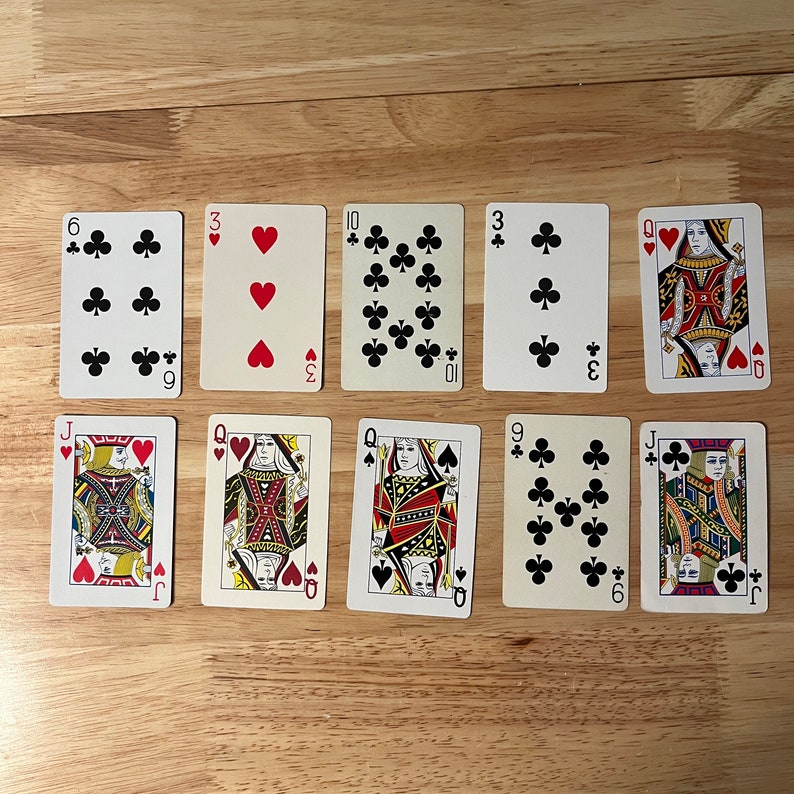 K&ouml;nnte beinhalten: Ein Satz von zehn Spielkarten, darunter ein Bube, eine Dame und eine 9 von Kreuz, eine 3, eine 10 und eine 6 von Kreuz, eine 3 von Herz und eine Dame von Herz. Die Karten haben alle die Standardgr&ouml;&szlig;e f&uuml;r Spielkarten und ein traditionelles Design.