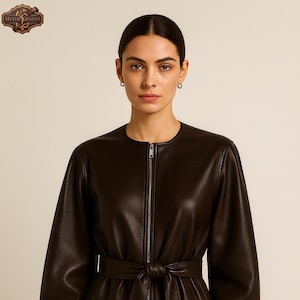 May include: A dark brown leather jacket with a zip-up front and a matching belt tied at the waist. The jacket has long sleeves and a round neckline. The logo "Mystic Genesis" is in the upper left corner.
