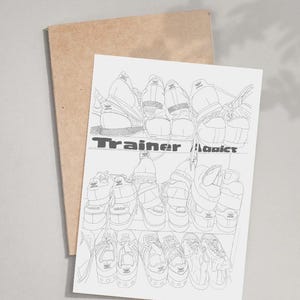 May include: A black and white line drawing of several pairs of sneakers on a shelf, with the text "Trainer Addicts" in a bold font. The drawing is on a white card, resting on a brown card.