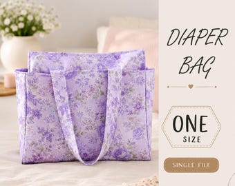 May include: A rectangular diaper bag featuring a light purple fabric with a detailed floral pattern in darker shades of purple. The text on the right side reads DIAPER BAG, ONE SIZE, SINGLE FILE, and INSTANT DOWNLOAD in a dark brown font.