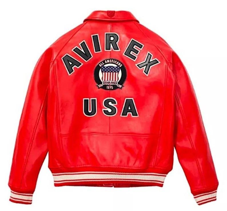 May include: A red leather jacket with the text "AVIREX" arched across the back in white block letters. Below the text is a circular patch with the words "ALL AMERICANS" and a US flag design. The word "USA" is printed in white block letters below the patch.