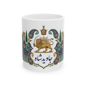 Puede incluir: Taza de cerámica blanca con un león dorado sosteniendo una espada, una corona y el texto persa "Javid Shah". El diseño incluye elementos de cachemira y arquitectónicos en verde azulado, azul y dorado.