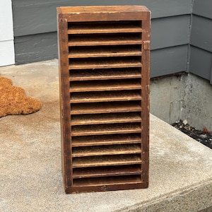May include: A tall, rectangular wooden document sorter featuring twelve horizontal shelves. The left side of the frame displays vertical numbering from 16 down to 5, with a weathered brown finish and visible wood grain throughout the structure.