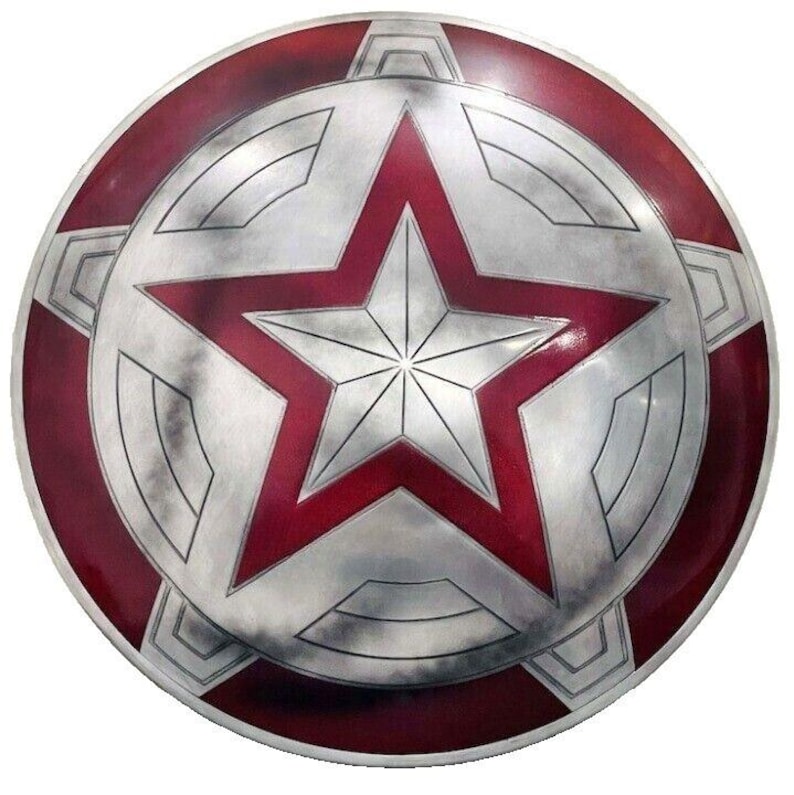 May include: A round, metallic shield with a red and silver star design. The shield has a red border and a silver center with a large red star in the middle. The star is surrounded by a silver geometric pattern.