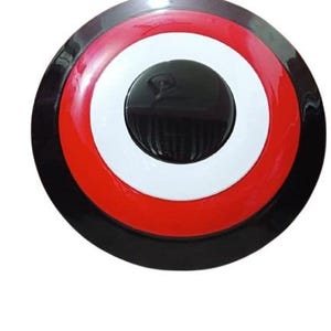 May include: A round shield with a black, red, white, and black color scheme. The shield has a central black circle with a raised center, surrounded by white and red concentric rings. The outer edge is black.