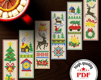 May include: A collection of seven Christmas-themed cross-stitch bookmarks. Each bookmark features a unique design, including a Christmas tree, reindeer, a house, and a car carrying a Christmas tree. The bookmarks are in various colors, including red, green, and yellow.