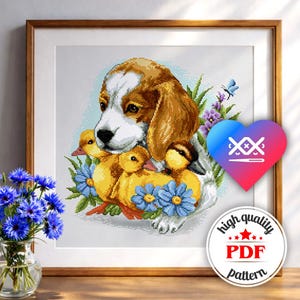 May include: Cross-stitch pattern featuring a beagle with three yellow ducklings, surrounded by blue flowers and greenery. The artwork is framed in a wooden frame. A heart-shaped logo and a round "high quality PDF pattern" sticker are in the image.