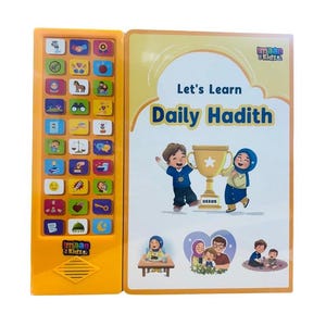 Puede incluir: Un libro infantil amarillo y blanco titulado "Let's Learn Daily Hadith" con ilustraciones de niños y un trofeo. El libro tiene un panel electrónico amarillo con botones e iconos. La marca "Imaan Kidz" es visible.