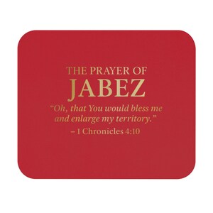 Pode incluir: Uma base para copos quadrada vermelha com cantos arredondados. O texto "THE PRAYER OF JABEZ" é impresso em dourado, juntamente com uma citação de 1 Crónicas 4:10. A base para copos é de cor vermelha lisa.