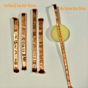 May include: Copper stir sticks for coffee, tea, and mixed drinks. The sticks have various embossed designs, including moons, stars, hearts, and peace signs. The text "Coffee & Tea Stir Sticks" and "Mix Drink Stir Stick" are visible.