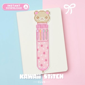 May include: A pink and white cross-stitch bookmark featuring a bear head and a multi-colored pen design. The bookmark has a polka dot pattern and the text "KAWAII STITCH CLUB" is visible.