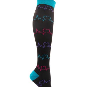 May include: Black compression socks with a teal cuff, heel, and toe. The socks feature a repeating pattern of hearts and heart rate lines in teal, purple, and pink. The socks are designed to reach the knee.