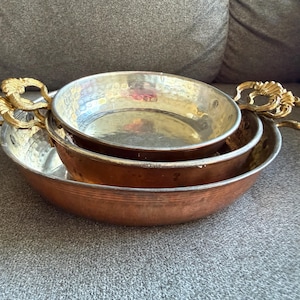 May include: A set of three ceramic mugs with a speckled, matte finish. The mugs are in shades of cream, light gray, and dark gray. Each mug has a simple, minimalist design, perfect for coffee or tea.