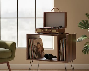 Könnte beinhalten: Ein Plattenspieler-Ständer im Mid-Century-Modern-Stil mit brauner Oberfläche. Der Ständer verfügt über ein integriertes Schallplattenfach und einen Plattenspieler im Vintage-Stil. Schwarze Kopfhörer liegen auf dem Regal. Der Ständer hat schwarze Haarnadelbeine.