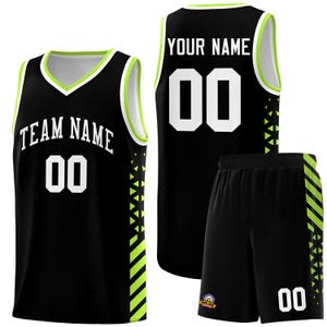 May include: Black basketball kit, including a vest and shorts. The vest displays "TEAM NAME" and the number "00" in white, with neon green trim. The shorts also feature the number "00" and neon green detailing. Suitable for sports.