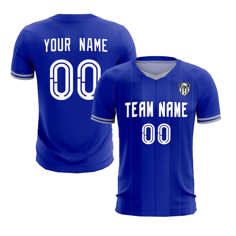 May include: Two blue soccer jerseys. One jersey displays "YOUR NAME" and the number "00" in white. The other jersey shows "TEAM NAME" and the number "00" in white. Both jerseys have a V-neck and a team logo.