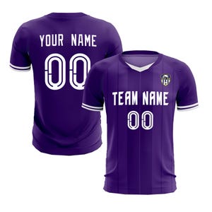 May include: Two purple football shirts. One shirt displays "YOUR NAME" and the number "00" in white. The other shirt shows "TEAM NAME" and the number "00" in white. Both shirts have white trim.