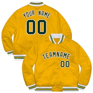 May include: Two yellow satin varsity jackets. One jacket has "YOUR NAME" and the number "00" in green. The other jacket has "TEAMNAME" and the number "00" in green. Both jackets have white, green, and yellow striped cuffs and collars.