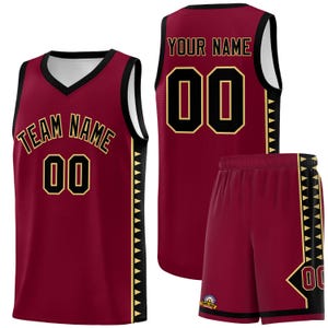 Op de afbeelding: Een bordeauxrood basketbaluniform, bestaande uit een shirt en een korte broek. Het shirt toont "TEAM NAME" en het nummer "00" in goud en zwart. De korte broek toont ook het nummer "00". Zwarte en gouden randen accentueren het uniform.