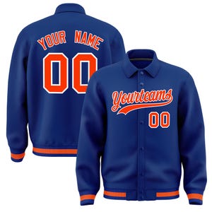 May include: A blue varsity jacket with orange trim on the collar, cuffs, and hem. The front features the text Yourteams and the number 00 in orange with white outlines. The back displays the text YOUR NAME and the number 00 in orange and white.