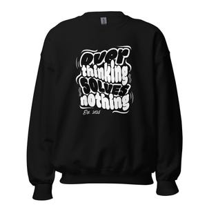 May include: Black sweatshirt with the white text "Overthinking Solves Nothing" in a bubble font. Below the text is "Est. 2025". The sweatshirt has a crew neck and long sleeves.