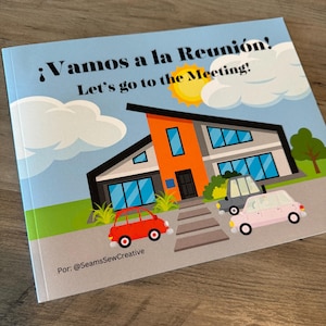 Könnte beinhalten: Kinderbuchcover mit dem Titel "¡Vamos a la Reunión! Let's go to the Meeting!" mit einer farbenfrohen Illustration eines modernen Hauses, Autos, Wolken und einer Sonne. Der Name des Autors ist ebenfalls enthalten.