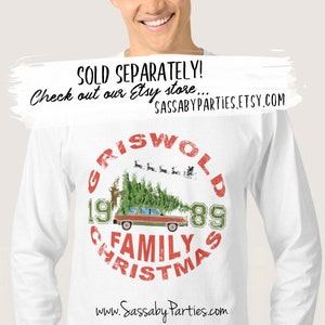 Pu&ograve; includere: Maglietta bianca a maniche lunghe con una grafica circolare rossa e verde che presenta il testo "Griswold Family Christmas 1989" e un'immagine di cartone animato di una station wagon con un albero di Natale in cima. La grafica include anche una piccola immagine di Babbo Natale e renne che volano nel cielo.