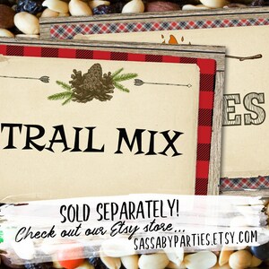 May include: Two printable signs with a rustic woodgrain background and red and black buffalo plaid border. The first sign says "TRAIL MIX" with a pine cone and arrow design. The second sign says "S'mores" with a stick figure roasting a marshmallow over a fire. The text at the bottom of the signs reads "SOLD SEPARATELY! Check out our Etsy store... SASSABYPARTIES.ETSY.COM"